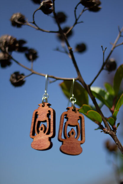 rustic lantern earrings, in orange, hanging on tree