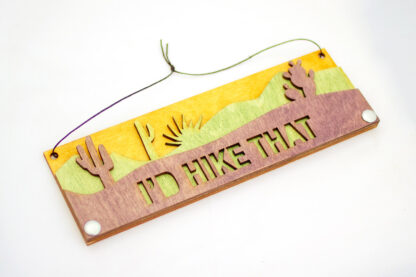 desert text sign which reads "I's hike that," in purple, skewed right